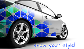 High-Performance Cast Vinyl Decals used on the back half of a white sedan. Vehicle decals are in a geometric pattern in the colors of cobalt blue, gold and turquoise.